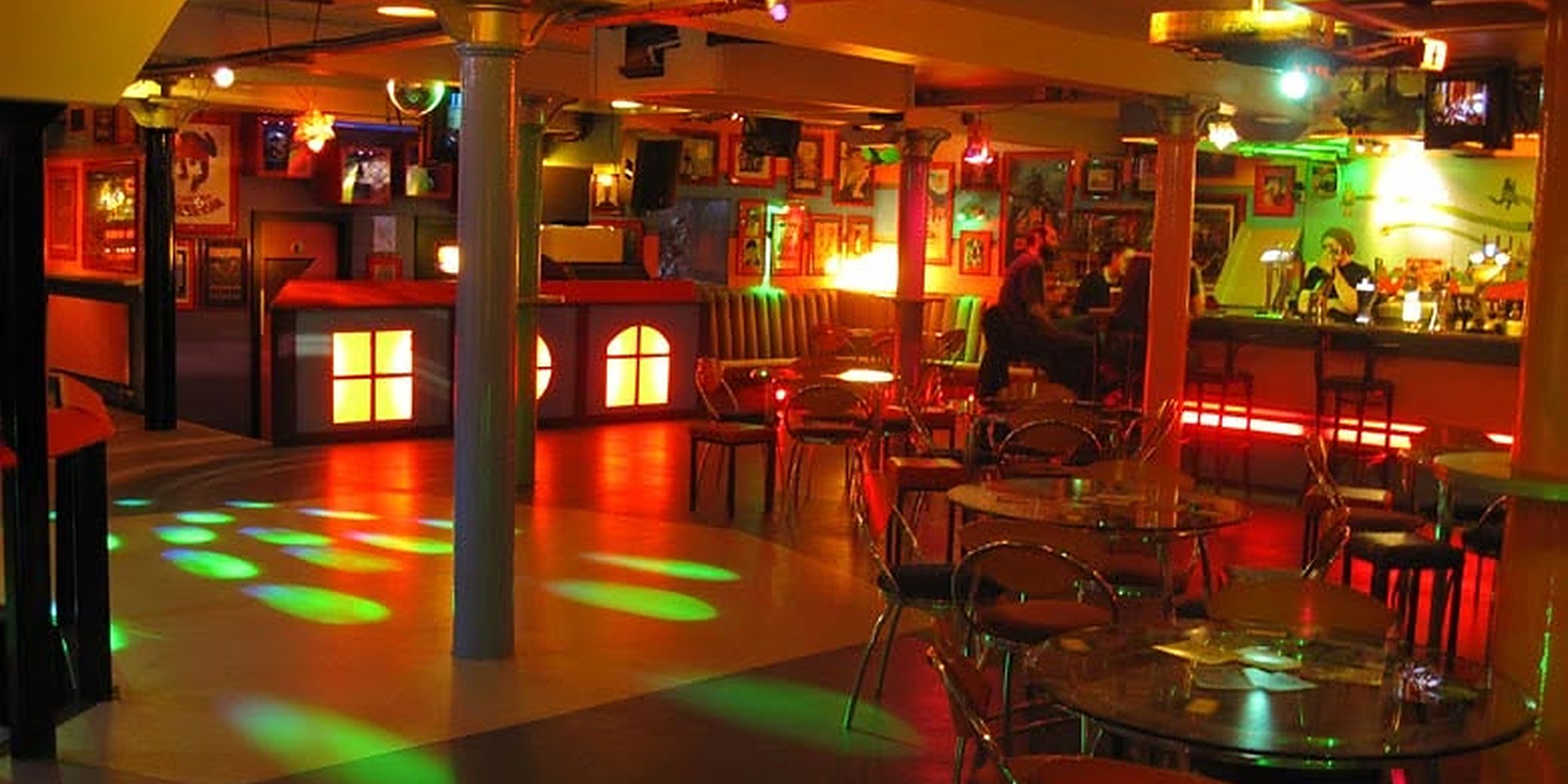 Fab Cafe's basement bar, with disco lights on the dancefloor and TV screens over the bar
