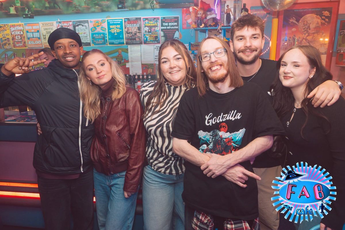 A group of friends in front of the wall of comics and posters